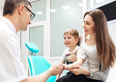 Mom holding baby in dental chair