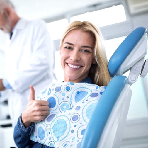 woman giving thumbs up in dental chair