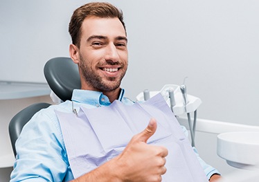 Male dental patient giving a thumbs up