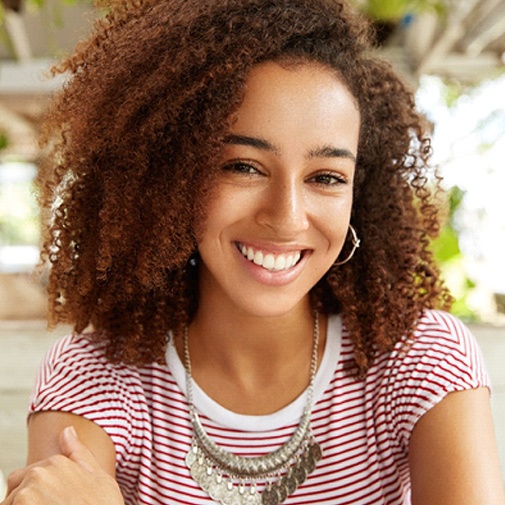 Woman with white, straight, healthy teeth smiling in café