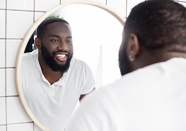 man smiling in a bathroom mirror